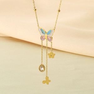 Detailed shot of golden butterfly necklace featuring enamel wings and dangling tassels
