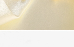 Vue macro d'un tissu de satin jaune pâle montrant une texture lisse et un fini brillant
