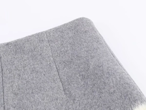Detail shot of grey faux fur texture and precise stitching on the fabric edge