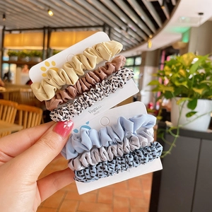 Chic leopard print fabric hair scrunchies set on display cards in natural cafe light