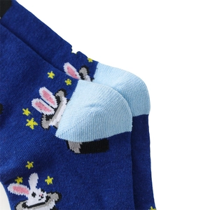 Detailed close-up of dark blue knitted sock heel with cartoon magic rabbit pattern