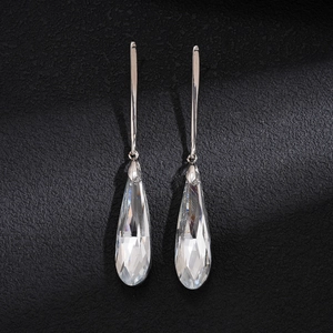 Top-down view of silver water drop earrings with transparent glass crystal pendants