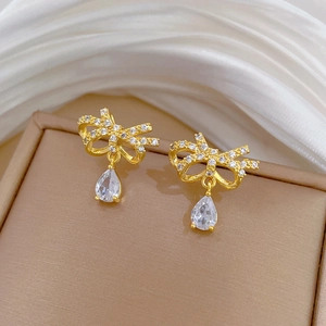 Detail of golden butterfly earrings with zircons and a pear-shaped drop crystal