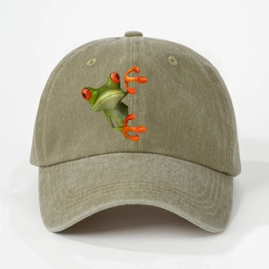 Close-up of a 3D red-eyed tree frog embroidery on a vintage olive washed cotton baseball cap
