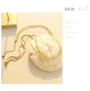 Detail of gold double-layered snake chain necklace with elegant heart pendant