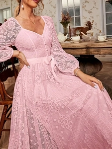 Gros plan d'une robe en dentelle rose avec col en V et motifs floraux sophistiqués