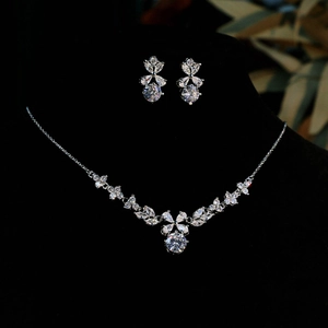 Sparkling zircon flower pendant necklace and earrings set on black velvet display