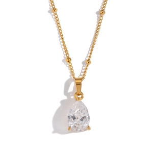 Detail of a pear-cut clear zircon pendant on a gold bead chain with a polished finish