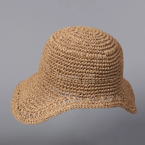 Detail of hand-woven straw hat showing intricate hollow patterns and raffia texture