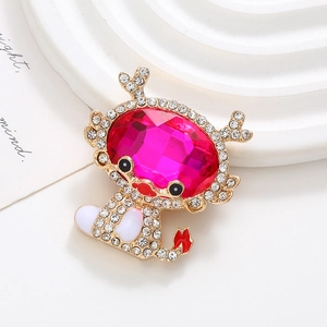 Detail of a gold crab brooch featuring a rose red gemstone and sparkling rhinestones