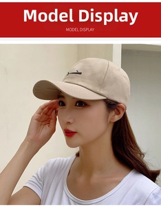 Close-up of beige canvas baseball cap featuring delicate black whale embroidery detail