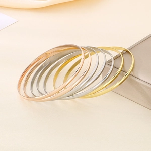 Set of seven 3.6mm polished stainless steel bangles in gold, silver, and rose gold finishes