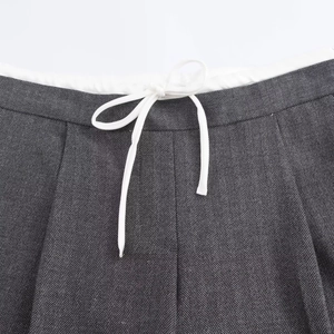 Detailed macro view of gray herringbone fabric with white piped waistband and drawstring