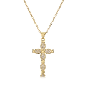 Close-up of gold-plated cross pendant with sparkling white cubic zirconia pavé setting