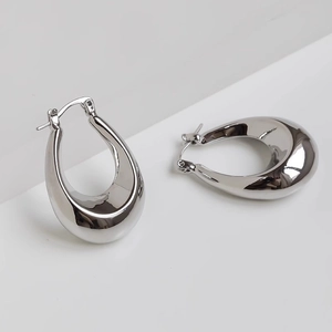 Polished silver teardrop hoop earrings with high mirror finish on minimalist background