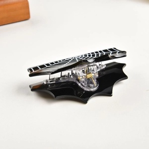 Detail view of the black bat wing hair claw clip with white spider web patterns