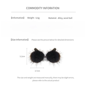Detailed view of oval twisted earrings with black pompom drops and silver needles