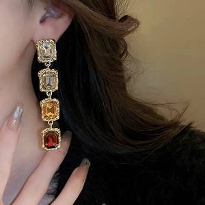 Detail view of vintage geometric gold earrings with gradient rhinestones on model
