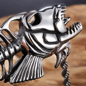 Close-up of a metallic silver fish bone pendant showing detailed craftsmanship and texture