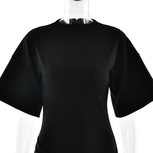 Detail view of the black crew neck dress featuring elegant pleats and smooth fabric