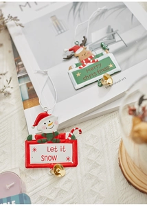 Detail of Christmas iron pendants with snowman, reindeer and bells on a soft background