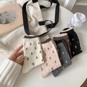 Vue détaillée de chaussettes en coton brodées de tulipes aux tons neutres et bords côtelés