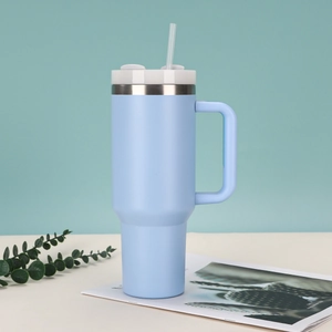Detail of 40oz light blue insulated travel mug with ergonomic handle and straw