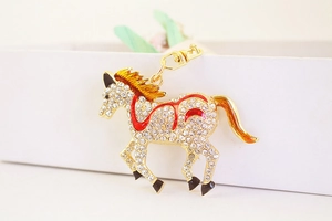 Detail of crystal horse keychain with red enamel accents and gold-plated lobster clasp
