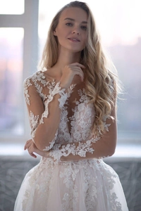Détails de broderie sur robe de mariée en dentelle blanche avec manches longues