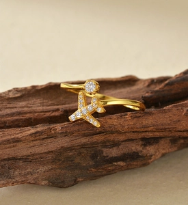 Macro shot of gold airplane ring with micro-pave zircon on a natural dark wood stand