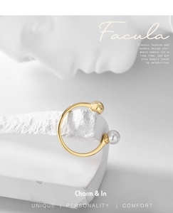 Detail of gold open ring with pearl and bead accent on a white sculptural bust