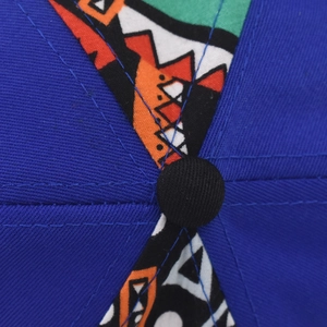 Détail du haut d'une casquette en coton bleu foncé avec broderie géométrique colorée