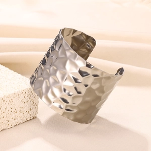 Close-up of hammered wide open bangle with geometric texture on elegant stone display
