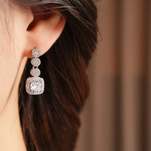 Close-up of elegant square silver stud earrings with sparkling cubic zirconia on model
