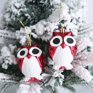 Adornos de búho de Navidad rojos brillantes con purpurina blanca en rama de abeto