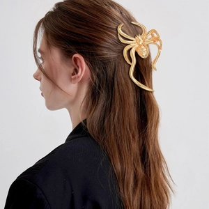 Golden spider hair claw clip shown on a model side profile for elegant hairstyling