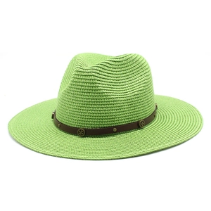 Detail of lime green straw jazz hat featuring a brown leather band with bronze rivets