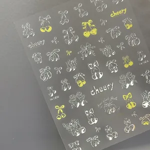 Macro detail of silver and yellow embossed nail stickers with cherry and angel motifs