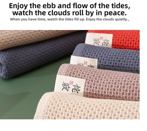 Close-up of textured waffle weave cotton towels in various colors with woven labels
