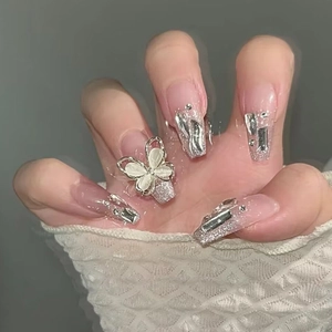 Sparkly pink press-on nails with silver glitter butterfly and rhinestone accents