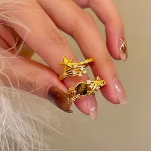 Nahaufnahme der 18K vergoldeten Vintage-Ringe mit Zirkonstern und Tigerauge-Inlay