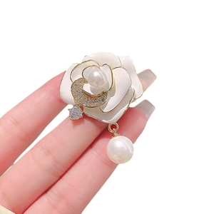 Élégante broche camélia blanc avec bords dorés, perles et cristaux scintillants