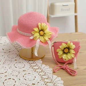 Dettaglio del set cappello e borsa in paglia rosa con girasoli e pizzi bianchi fini