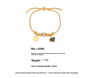 Detail view of gold snake chain bracelet with sparkling rhinestone hearts and beads