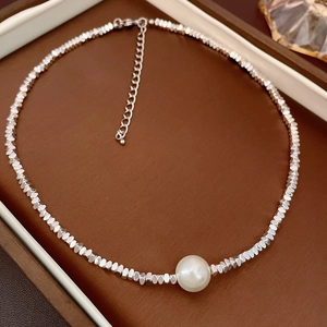 Metallic beaded necklace with freshwater pearl and adjustable lobster clasp on display