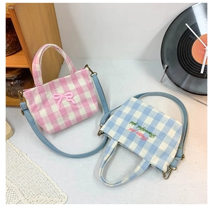 Checkered canvas kids handbags with pink bow and blue embroidery in artistic setting