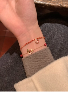 Detail of 18k gold-plated lucky horse charm and red beaded bracelet set for women
