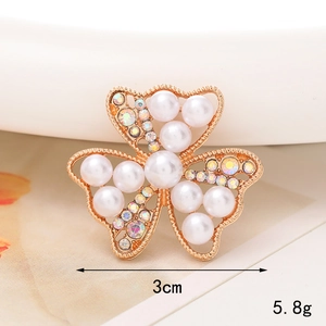 Detalle de dije de flor dorada con perlas y strass, mostrando el tamaño de 3cm