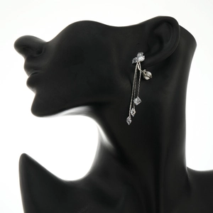 Silver tassel earrings with cubic zirconia and pearl drops on a model ear