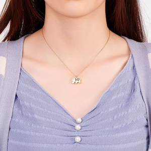 Elegant gold elephant pendant necklace with zircon eye detail on a female model